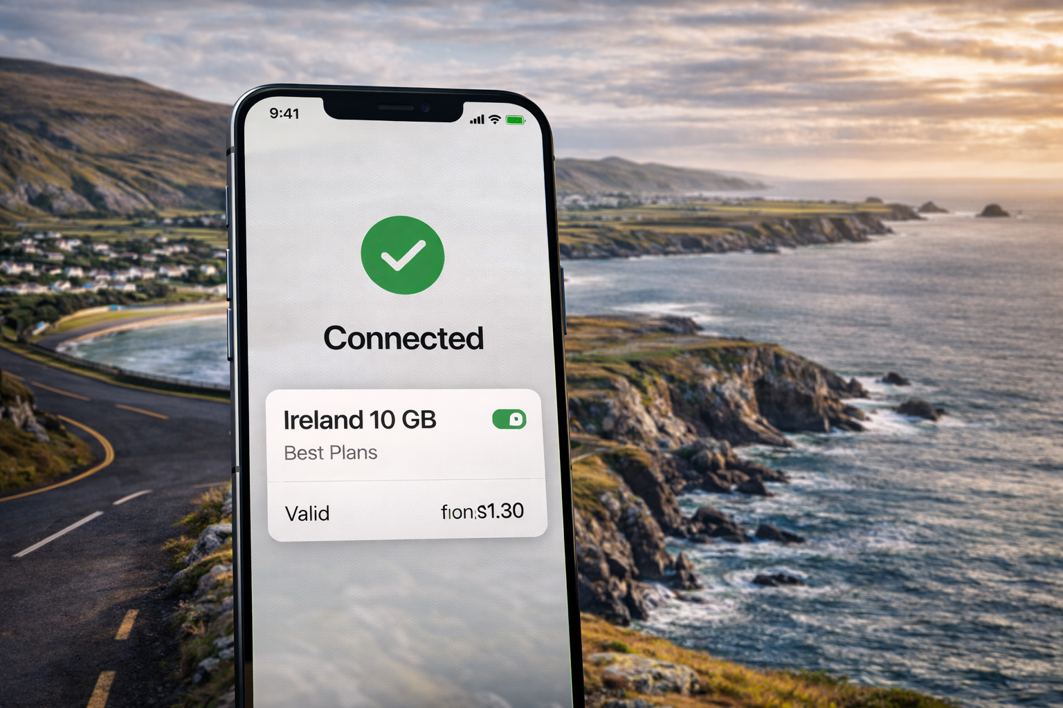 סמארטפון עם eSIM פעילה ואינטרנט סלולרי עובד על רקע חוף ירוק, אוקיינוס וכביש נופי באירלנד.
