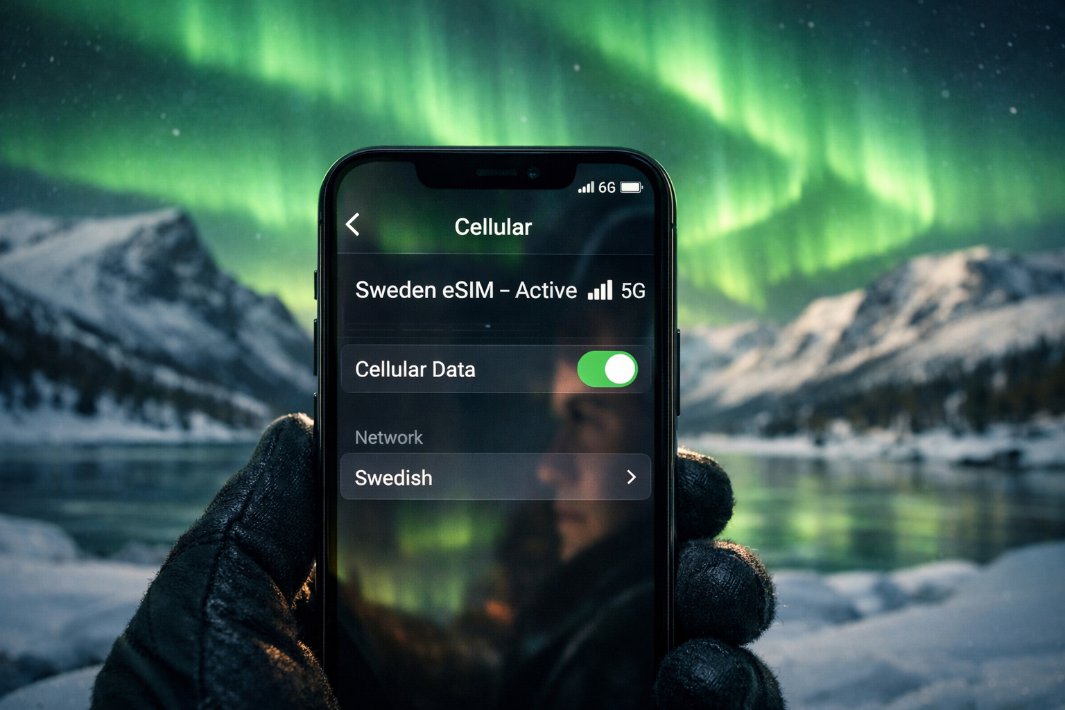 A smartphone with an active Sweden eSIM against the Northern Lights in Lapland