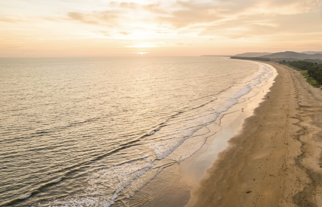 חוף קוקס בזאר הארוך ממבט על, הנמשך אל האופק עם גלים עדינים ומעט אנשים