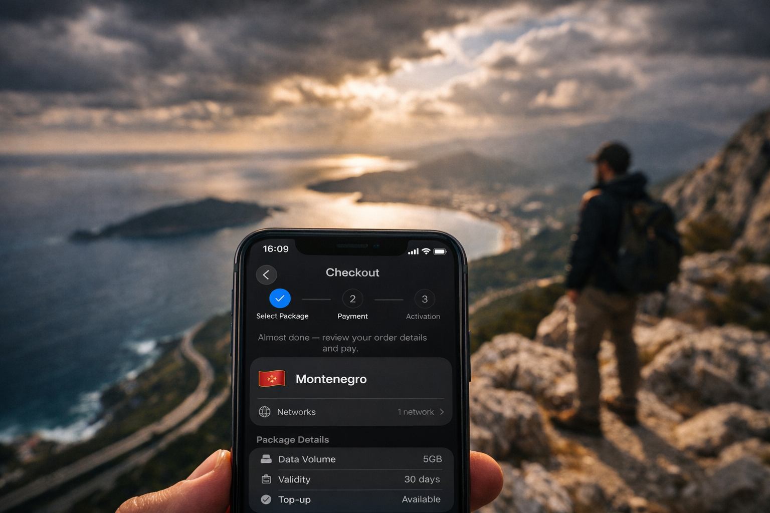 A smartphone showing Montenegro eSIM setup with mountains and coastline in the background