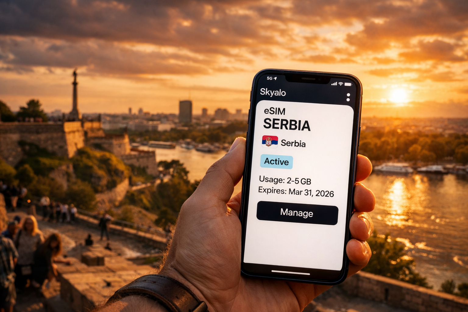 A smartphone with an active Skyalo eSIM for Serbia against the backdrop of Belgrade’s panorama and Kalemegdan Fortress at sunset.