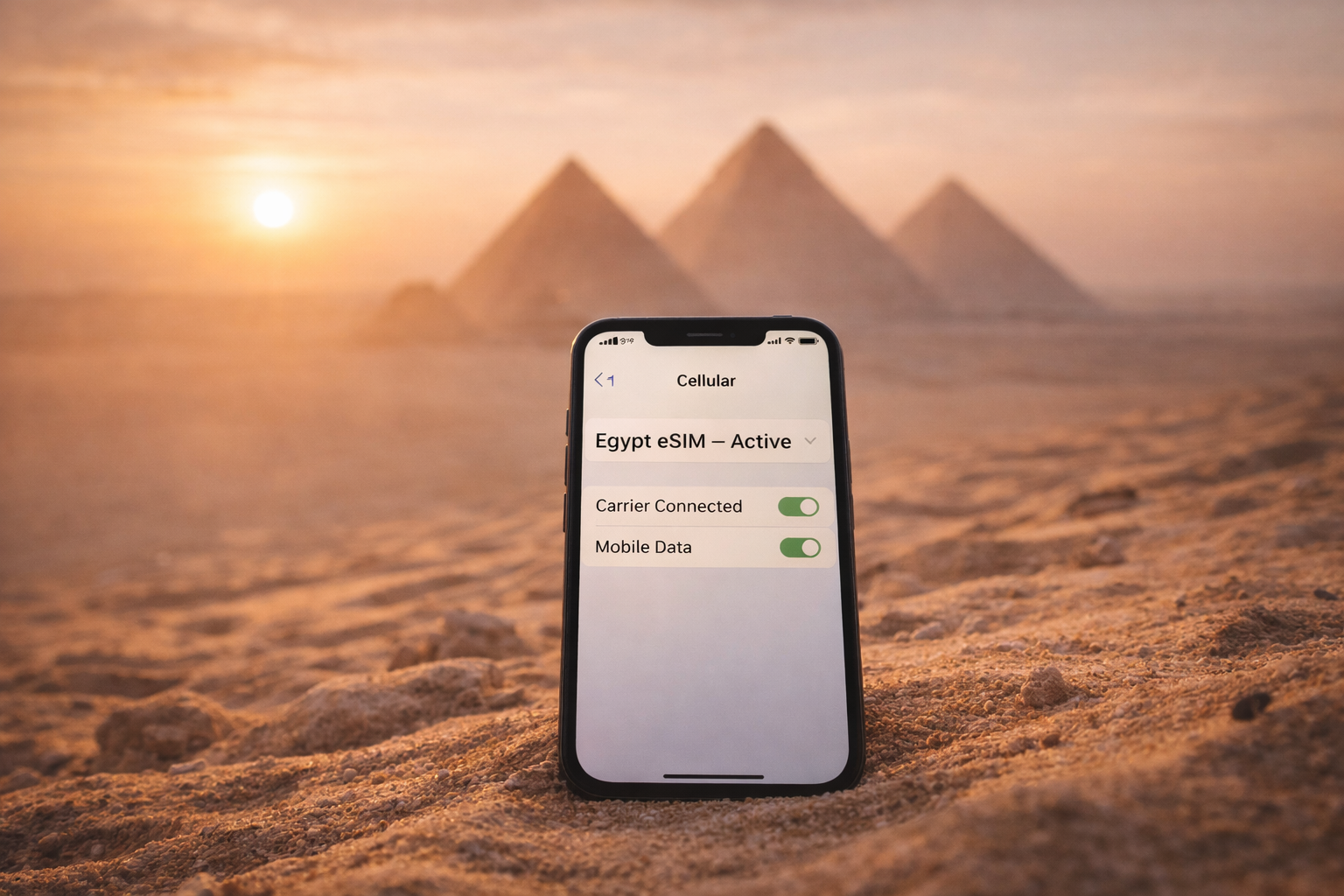 A smartphone with an active eSIM in Egypt with pyramids in the desert at sunrise in the background