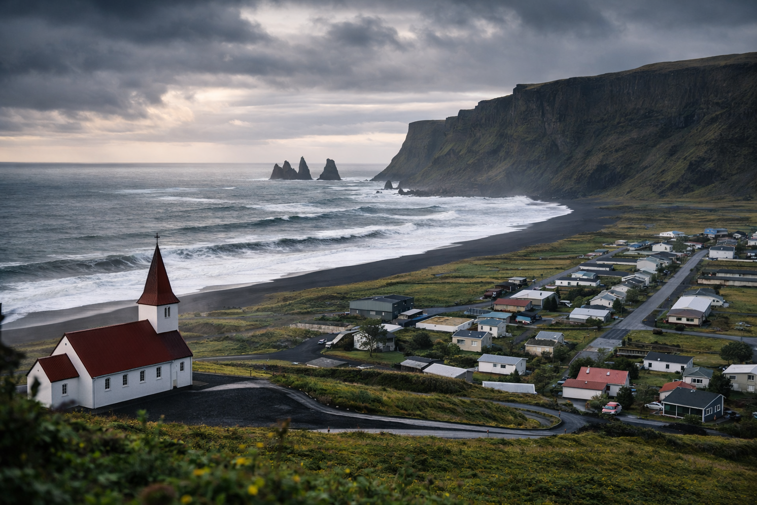 Vīka Islandē ar melno pludmali, okeāna viļņiem, vulkāniskām klintīm un nelielu baznīcu kalnā